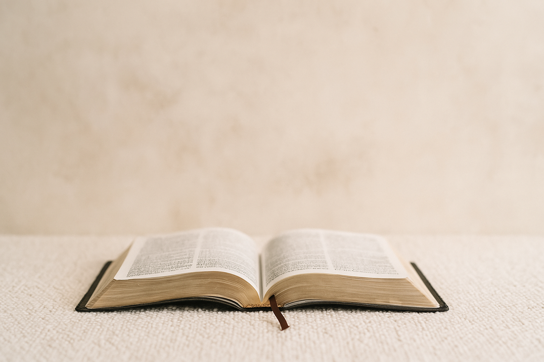 An open Bible resting on soft linen in warm light